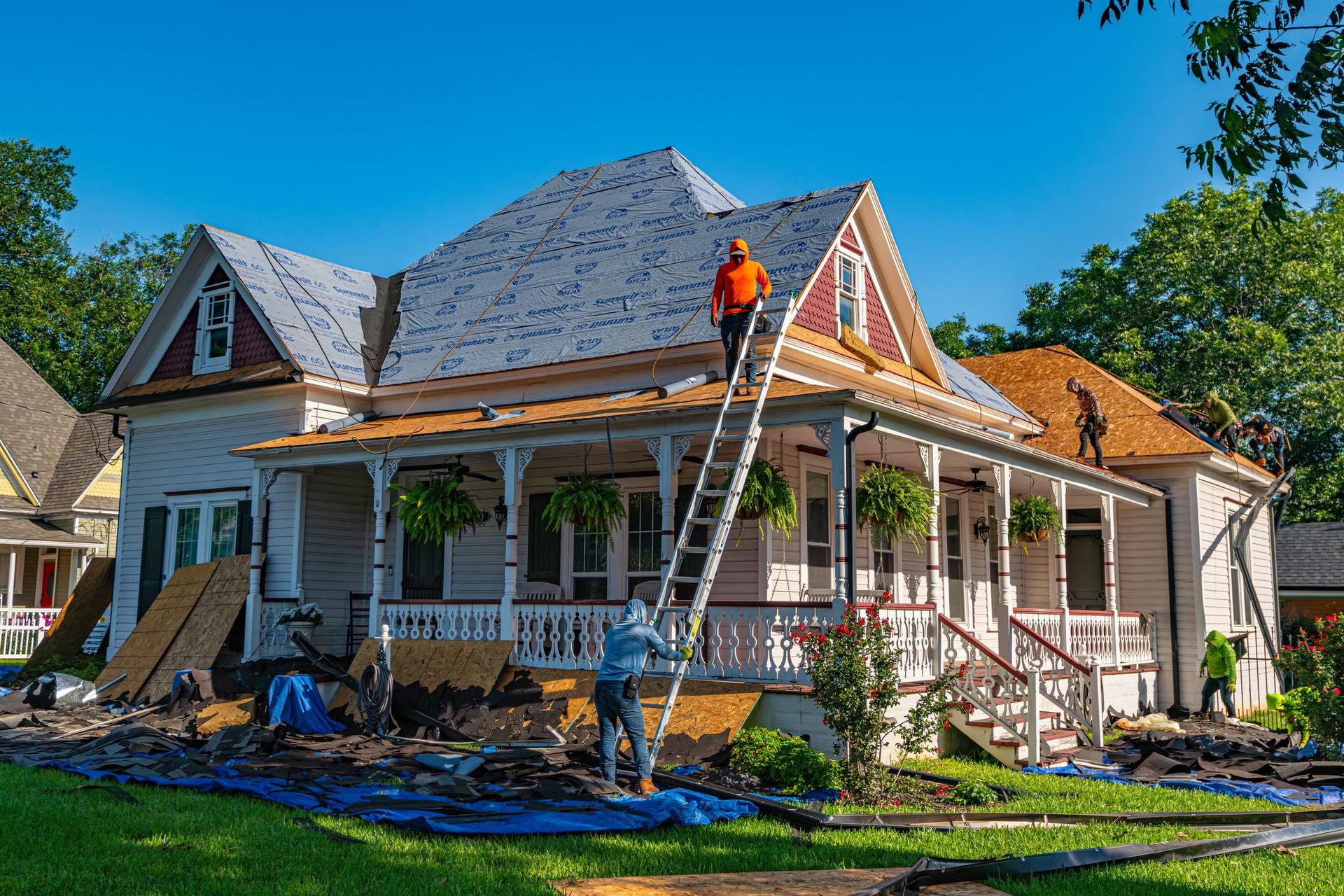 Roofing crew installing a new roof on a two-story home